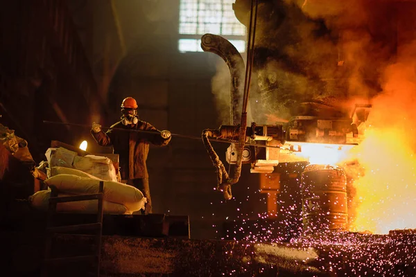 ファウンドリーショップでインゴットを鋳造する冶金学者 — ストック写真