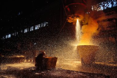 Bir sıcak metal akıntısı kepçeye dökülüyor. Elektrikli ark fırını EAF. Metalürji.