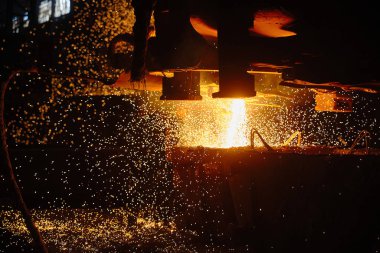 Bir sıcak metal akıntısı kepçeye dökülüyor. Elektrikli ark fırını EAF. Metalürji.
