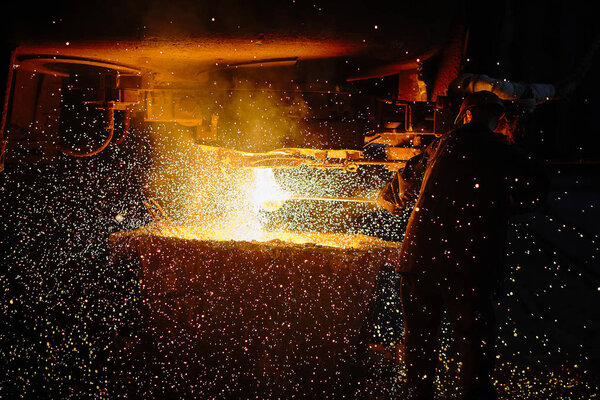 Steelmaker at ingot casting. Electric arc furnace shop EAF. Metallurgy.