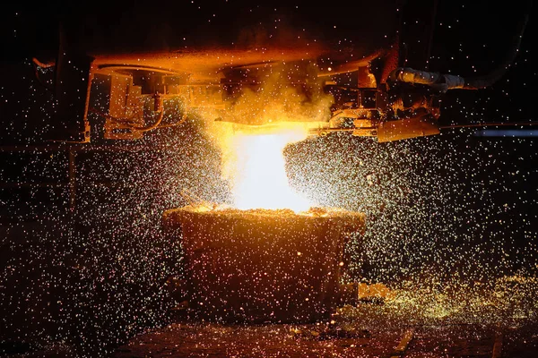 Een stroom heet metaal stroomt in de pan. Elektrische boogoven winkel EAF. Metallurgie. — Stockfoto