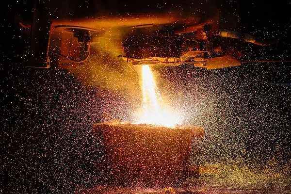 Een stroom heet metaal stroomt in de pan. Elektrische boogoven winkel EAF. Metallurgie. — Stockfoto