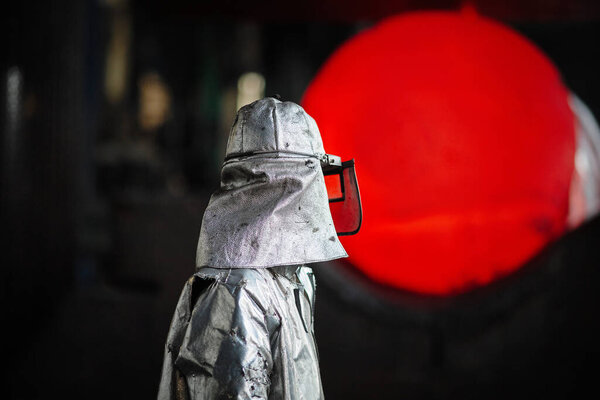 Worker blacksmith in protective clothing at the Forging shop