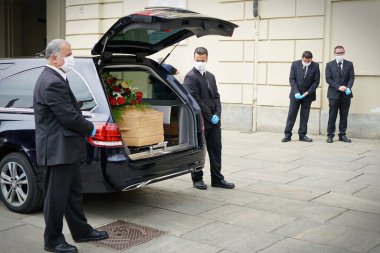 Employees of the funeral services company next to the coffin of a COVID-19 victim, in Turin, Italy, April 2020. clipart