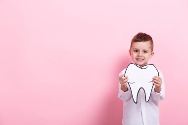 Küçük bir çocuk papercraft diş üzerinde pembe bir arka plan ile. Sağlık kavramı