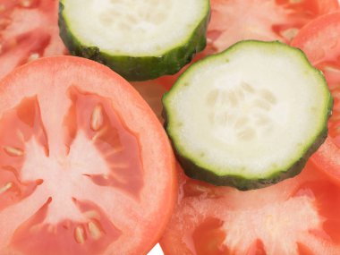 Dilimlenmiş yeşil salatalık ve kırmızı domates en iyi görünümünü arka plan, closeup olarak. Salata için taze sebze kavramı