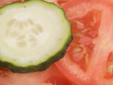 Dilimlenmiş yeşil salatalık ve kırmızı domates en iyi görünümünü arka plan, closeup olarak. Salata için taze sebze kavramı