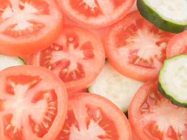 Dilimlenmiş yeşil salatalık ve kırmızı domates en iyi görünümünü arka plan, closeup olarak. Salata için taze sebze kavramı