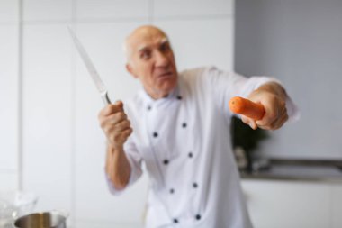 Mutfakta bir havuç kesim bir bıçakla bir huysuz yaşlı adam şef. Bir akşam yemeği için sebzeleri Dilimleme bir kavram.