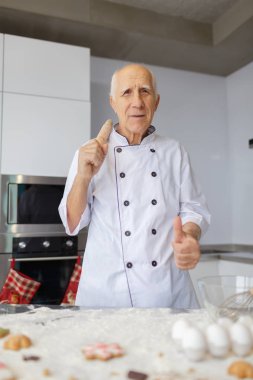 Yaşlı hamur yoğurma ve mutfakta oklavayla kullanarak Şef dostum. Çiğ hamur ekmek için hazırlanıyor unu yemek.