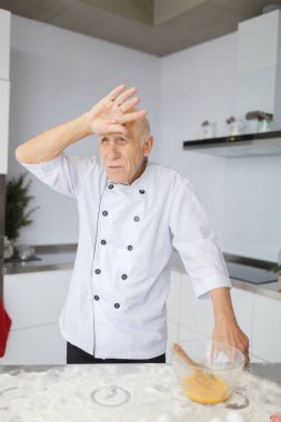 Mutfakta hamur yoğurma yorgun yaşlı adam şef. Unu hamur hazırlama bir fırın için cook.