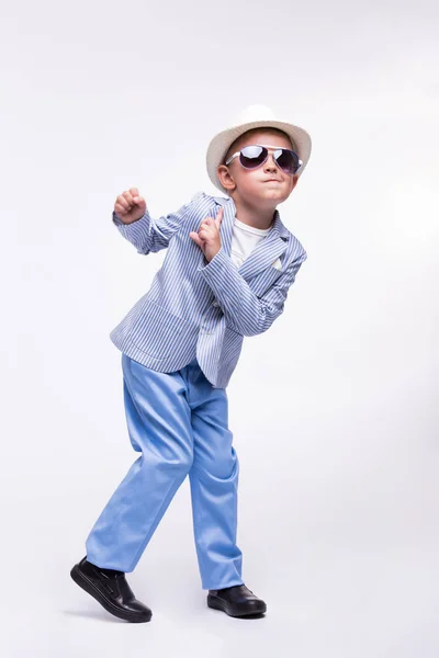 Un niño feliz con gafas de sol, un sombrero y un traje de moda aislado sobre un fondo blanco. concepto de niños divertidos —  Fotos de Stock