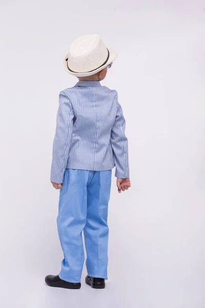 Маленький мальчик в синем костюме и шляпе на белом фоне. Концепция одежды для детей — стоковое фото