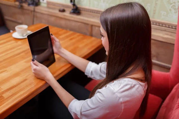 Een gelukkig jongedame communiceren op het touch scherm tabletcomputer in café. Moderne technologieën concept — Stockfoto