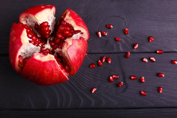 Ein Blick von oben auf einen roten Granat. Gesunder saurer Granatapfel auf schwarzem Hintergrund. — Stockfoto