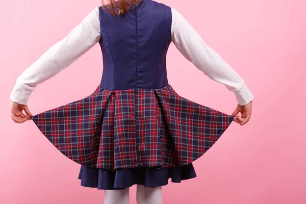 Uma menina de uniforme escolar com um fundo cor de rosa. Educação, conceito de escola — Fotografia de Stock