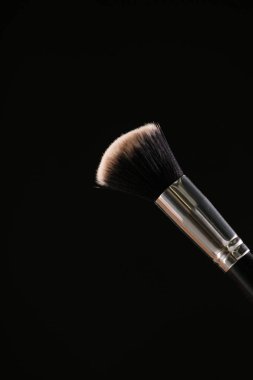 Siyah arka plan üzerine toz allık patlama ile kozmetik fırçalar makyaj
