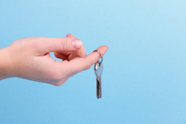 Anahtarı elinde ev. El tutma palmiye ve anahtar üstünde parmak kadar evde