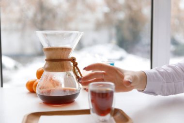 Bir fincan çay, bir daire, bir şube yaşayan bitki, mum olan bir portakal mandarin.winter atmosfere