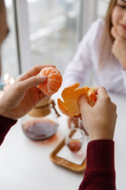 Bir fincan çay, bir daire, bir şube yaşayan bitki, mum olan bir portakal mandarin.winter atmosfere