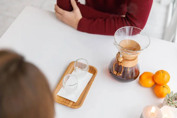 Una taza de té, un platillo, una rama de una planta viva, una mandarina anaranjada.Ambiente invernal con velas — Foto de Stock