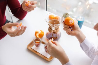 Bir fincan çay, bir daire, bir şube yaşayan bitki, mum olan bir portakal mandarin.winter atmosfere