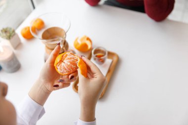 Bir fincan çay, bir daire, bir şube yaşayan bitki, mum olan bir portakal mandarin.winter atmosfere