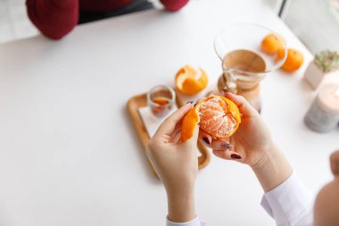 Bir fincan çay, bir daire, bir şube yaşayan bitki, mum olan bir portakal mandarin.winter atmosfere