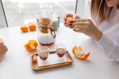 Bir fincan çay, bir daire, bir şube yaşayan bitki, mum olan bir portakal mandarin.winter atmosfere