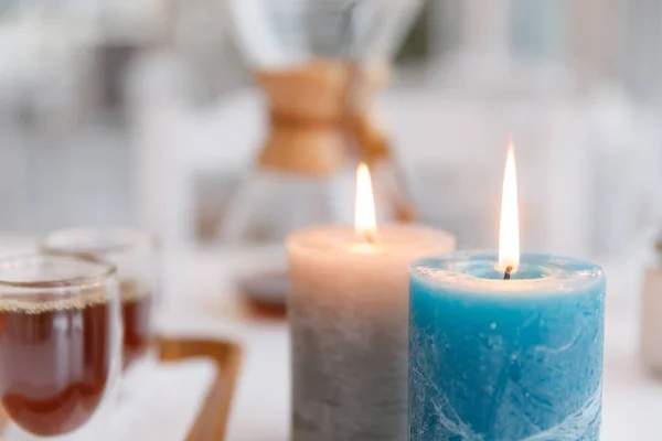 Una taza de té, un platillo, una rama de una planta viva, una mandarina anaranjada.Ambiente invernal con velas — Foto de Stock