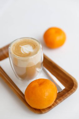 bir ahşap tepsi, mumlar ve mandalina latte. Evde rahat kahve molası