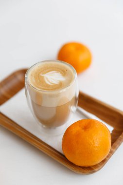 bir ahşap tepsi, mumlar ve mandalina latte. Evde rahat kahve molası