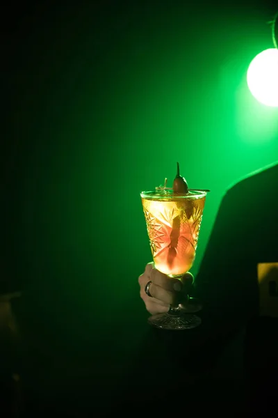 Expert barman is making cocktail at night club.bartender with cocktail and orange peel preparing cocktail at bar. alcohol drinks, people and luxury concept