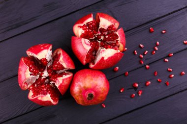 Olgun nar meyve ahşap antika arka plan üzerinde. Ahşap bir masa nar dilimleri. Üstten Görünüm. Uzay kopyalayın. Rustik tarzı