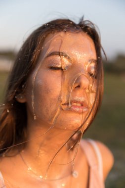 Yüzünde bal ile genç güzel kadın. Sağlıklı mükemmel cilt. Bal tedavisi.