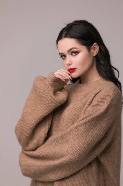 Güzellik kadını yüz portre. Güzel Spa modeli mükemmel taze temiz ten kızla. Kameraya bakarak ve gri arka plan üzerinde gülümseyen esmer kadın. Güzel saç modeli Gençlik ve cilt bakım kavramı