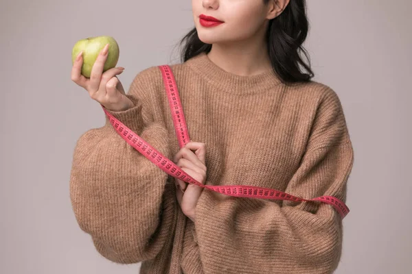 Eat good food for good shape concepts. Woman measuring her body by measure tape have a vegetables