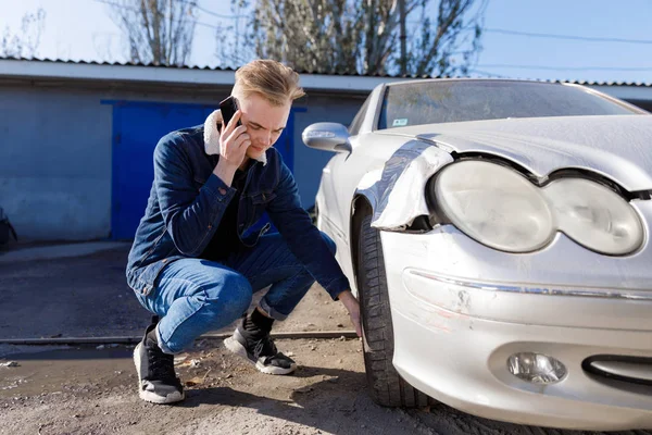 A man calling for help after a traffic accident on a mobile phone. Concept - car accident.