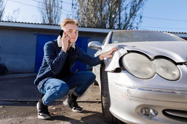A man calling for help after a traffic accident on a mobile phone. Concept - car accident.
