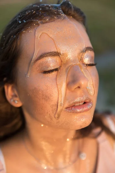Young beautiful woman with honey on her face. Healthy perfect skin. Honey treatment.