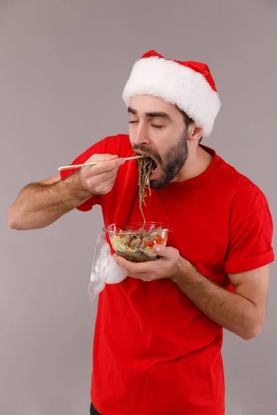 Stilig man i jul hatt hålla låda med mat. — Stockfoto