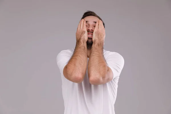 一个留着胡子的男人在灰色背景危机, 情绪和压力的概念白色 t恤 — 图库照片
