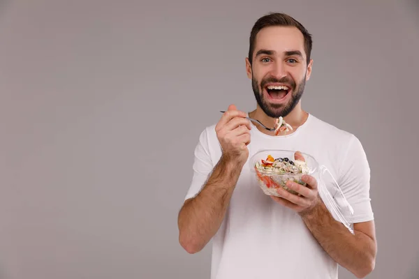 Мужчина ест веганскую миску с палочками для еды. Мужчина держит чашу в руках — стоковое фото
