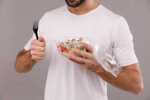 A man eats vegan poke bowl with chopsticks. A man holds poke bowl in his hands — Stock Photo, Image