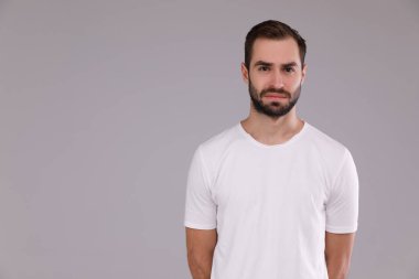 gri bir arka plan üzerinde beyaz bir T-shirt bir sakallı bir adam