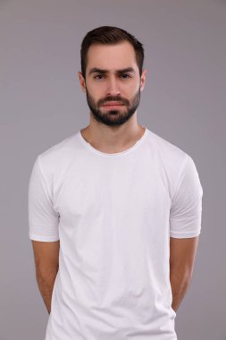 gri bir arka plan üzerinde beyaz bir T-shirt bir sakallı bir adam