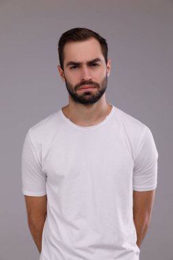 gri bir arka plan üzerinde beyaz bir T-shirt bir sakallı bir adam