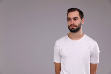 gri bir arka plan üzerinde beyaz bir T-shirt bir sakallı bir adam