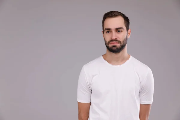 Egy ember, a szakáll, a szürke alapon fehér póló — Stock Fotó
