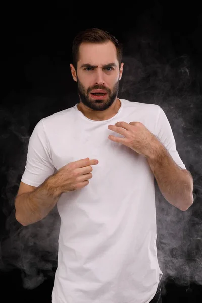 Парень в белой футболке задыхается от дыма — стоковое фото